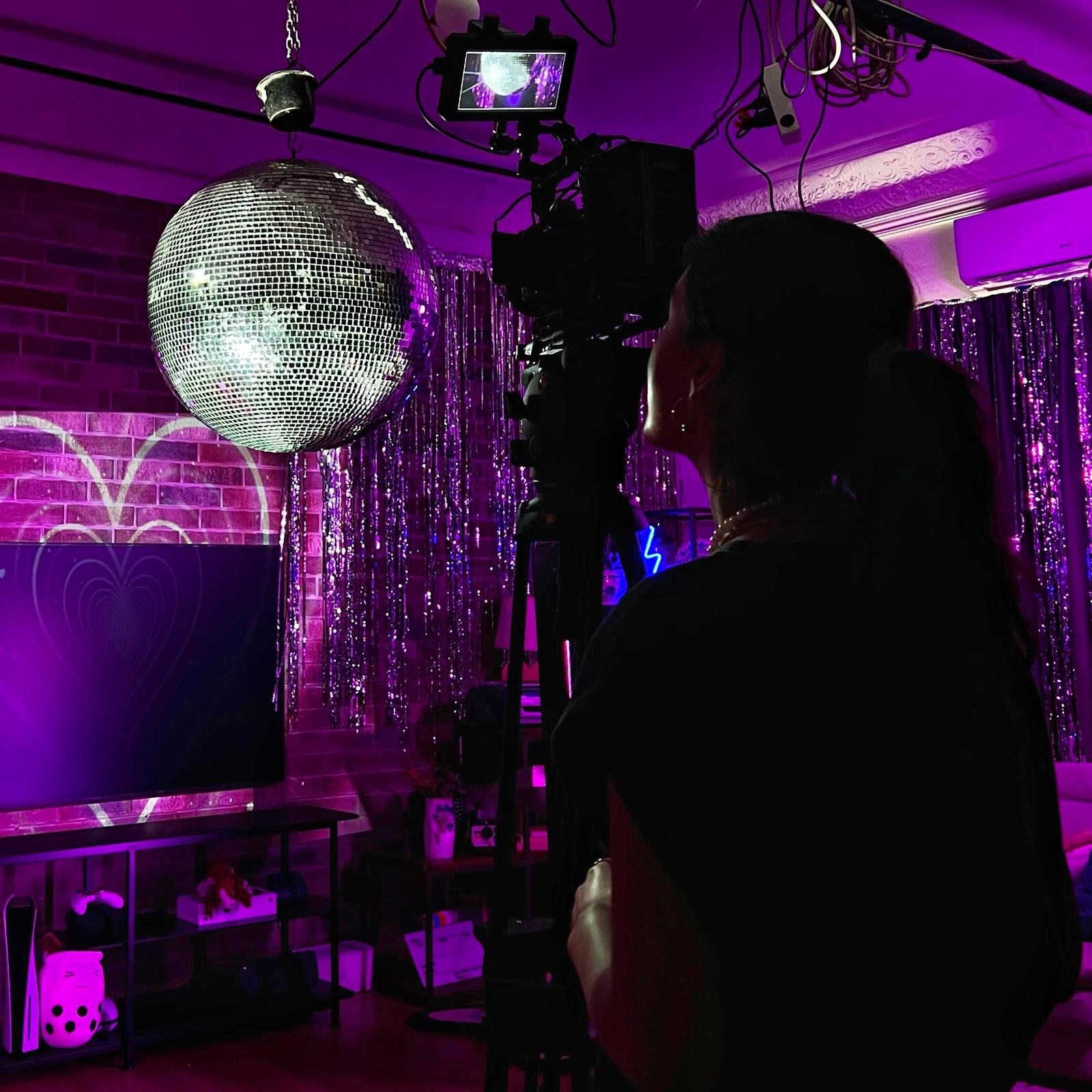 Filming a music video under purple light and a disco ball
